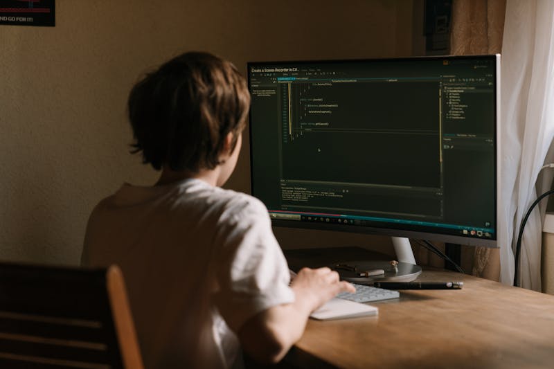 Child learning to code on a computer with colorful programming blocks