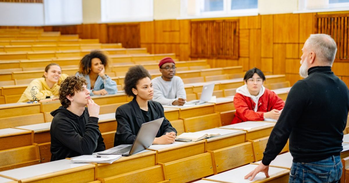 A lecturer addressing students in a university lecture hall