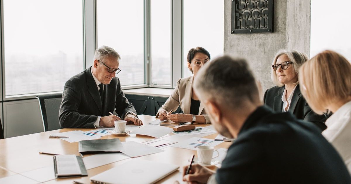 Executives around a boardroom table during a leadership meeting