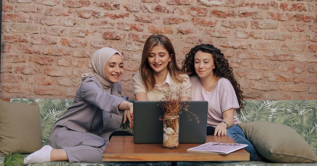 Three colleagues collaborating over a laptop during a placement