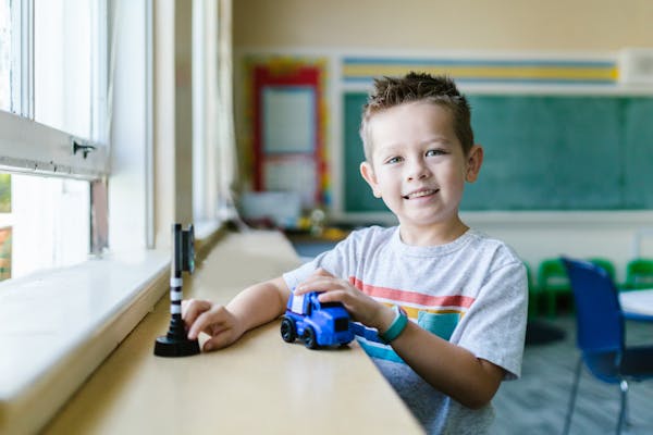 Preschooler tracing letters in a writing practice workbook