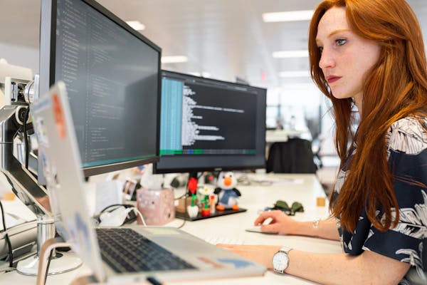 Woman working on code at a computer
